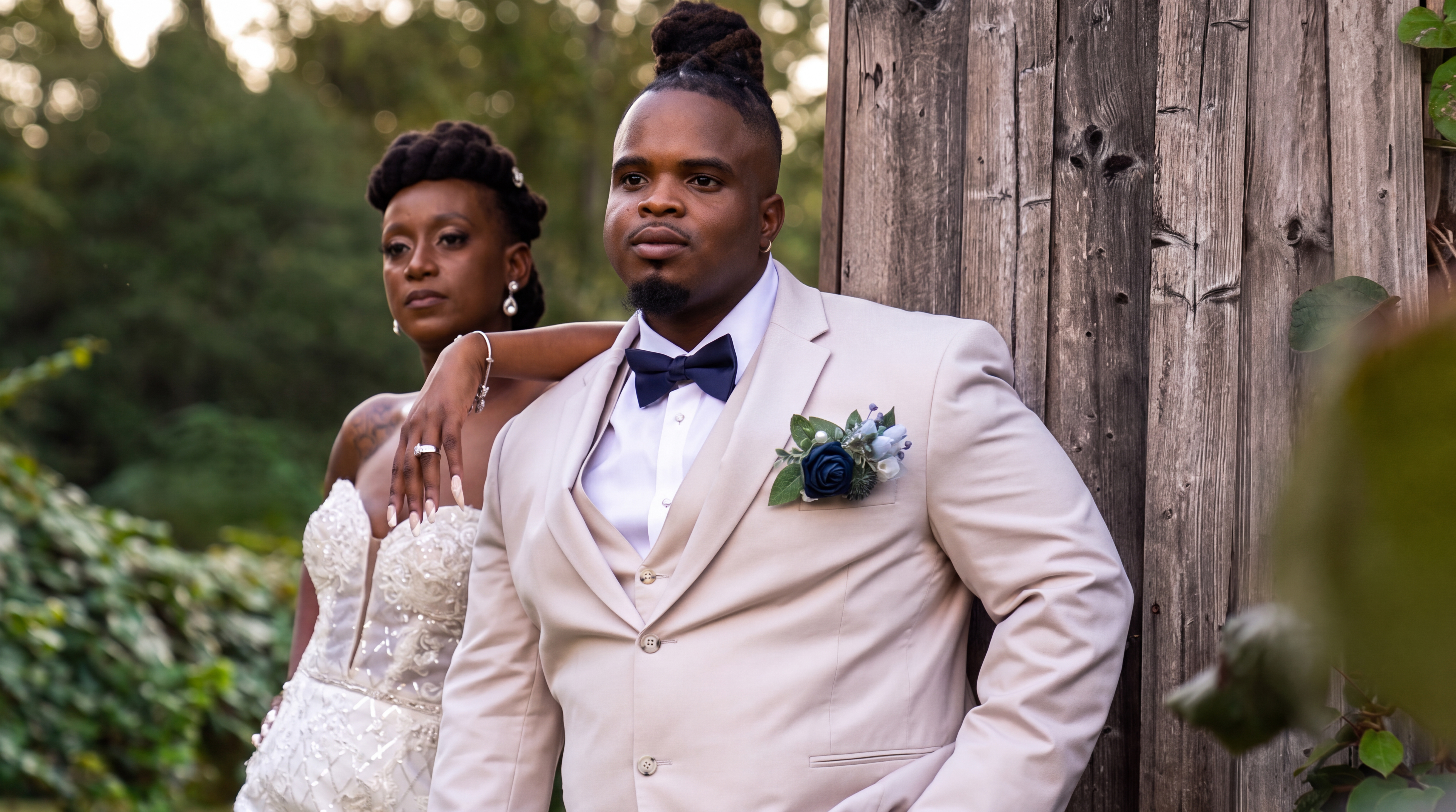Bride and groom posing together in formal wedding attire outdoors